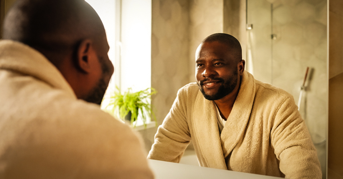 An image of a man looking into a mirror, reflecting his future self.