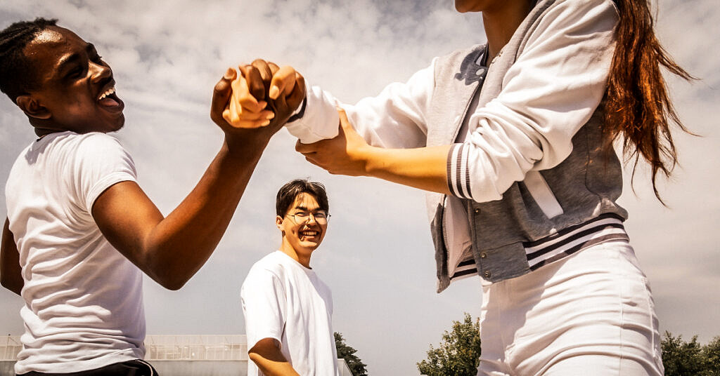 A man and a woman engaged in a playful arm wrestling contest symbolizing relationship negotiations