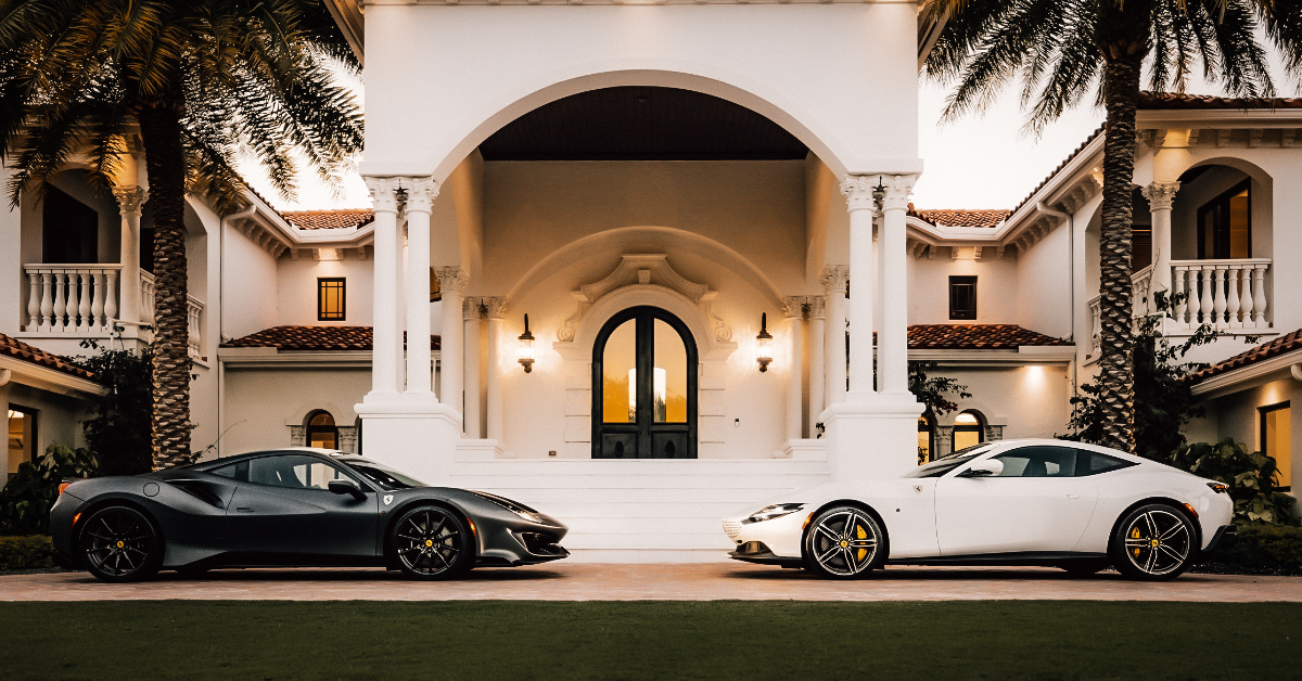 A luxurious mansion with expensive cars parked outside