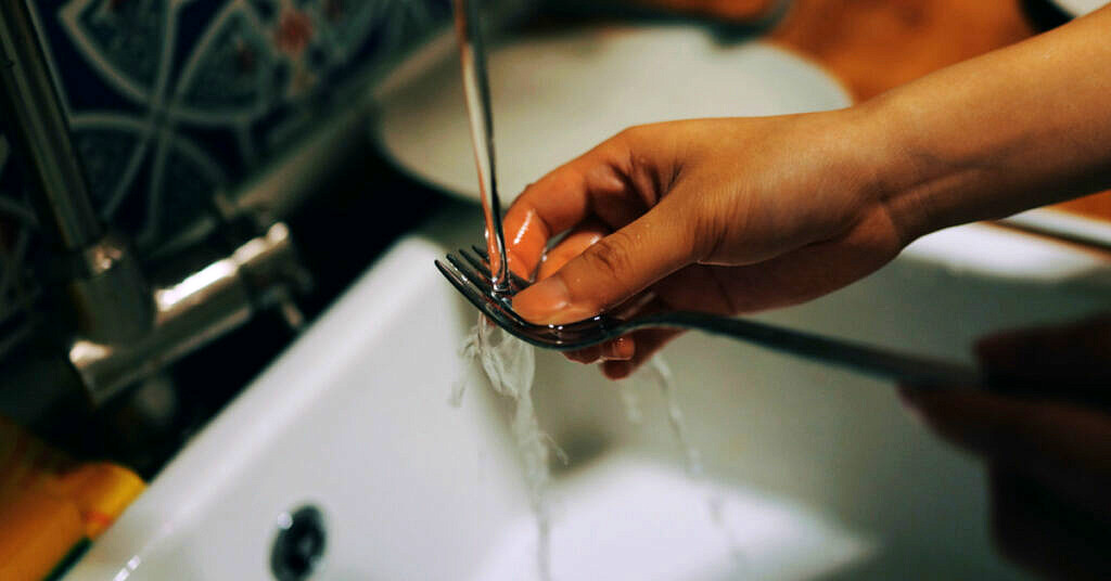 A thoughtful man washing dishes